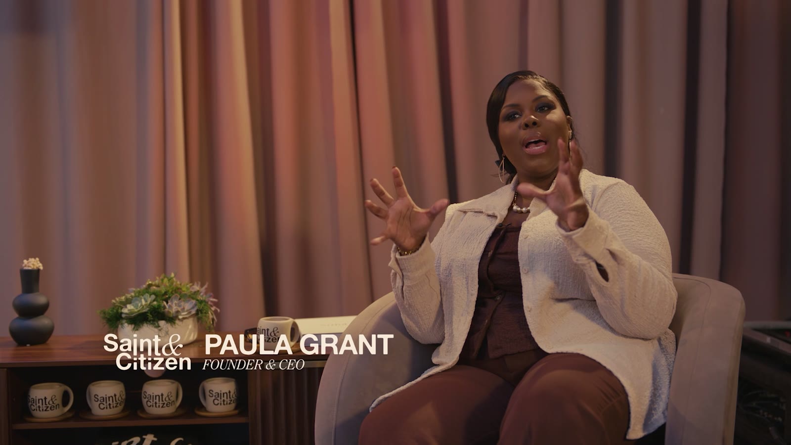 Paula Grant seated, speaking at a Saint and Citizen event